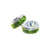 A pair of green beads sitting on top of a white surface.