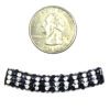 A coin and some beads are next to each other.