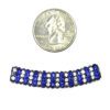 A close up of a coin next to a bead
