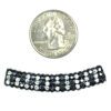 A small coin and some beads on the side of it