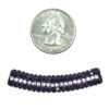 A coin and some purple beads on a white background