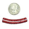 A close up of a coin next to a bead