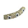 A curved piece of jewelry with gold and black stones.