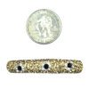 A coin and some gold beads next to each other