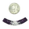 A close up of a coin next to a bead