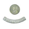 A coin and some beads are next to each other