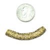 A small amount of gold beads are next to a penny for scale.