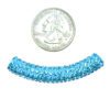 A small coin next to a blue bead