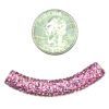 A pink bead is next to a penny for size.