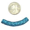 A coin and some blue beads on a white background