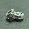 A pair of silver colored metal beads sitting on top of a table.