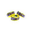 Three yellow and purple beads are sitting on a white surface.