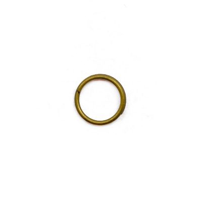 A gold colored metal ring sitting on top of a white surface.