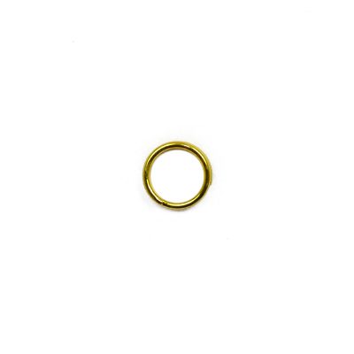 A gold colored metal ring sitting on top of a white surface.