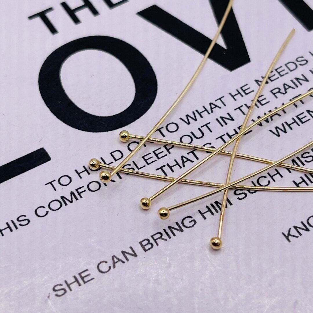 A close up of some gold pins on top of the words