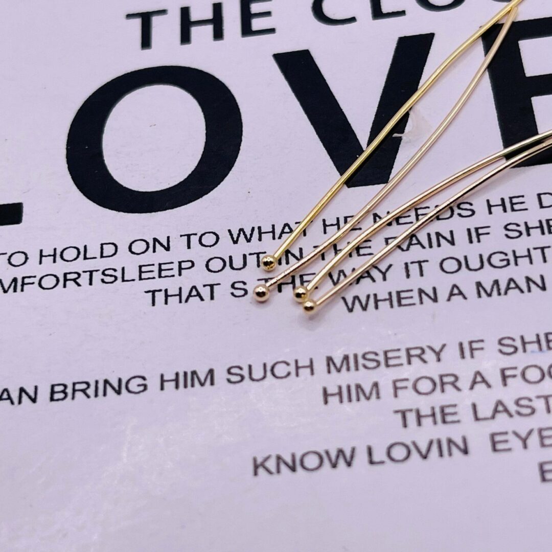 A close up of some gold pins on top of a poem