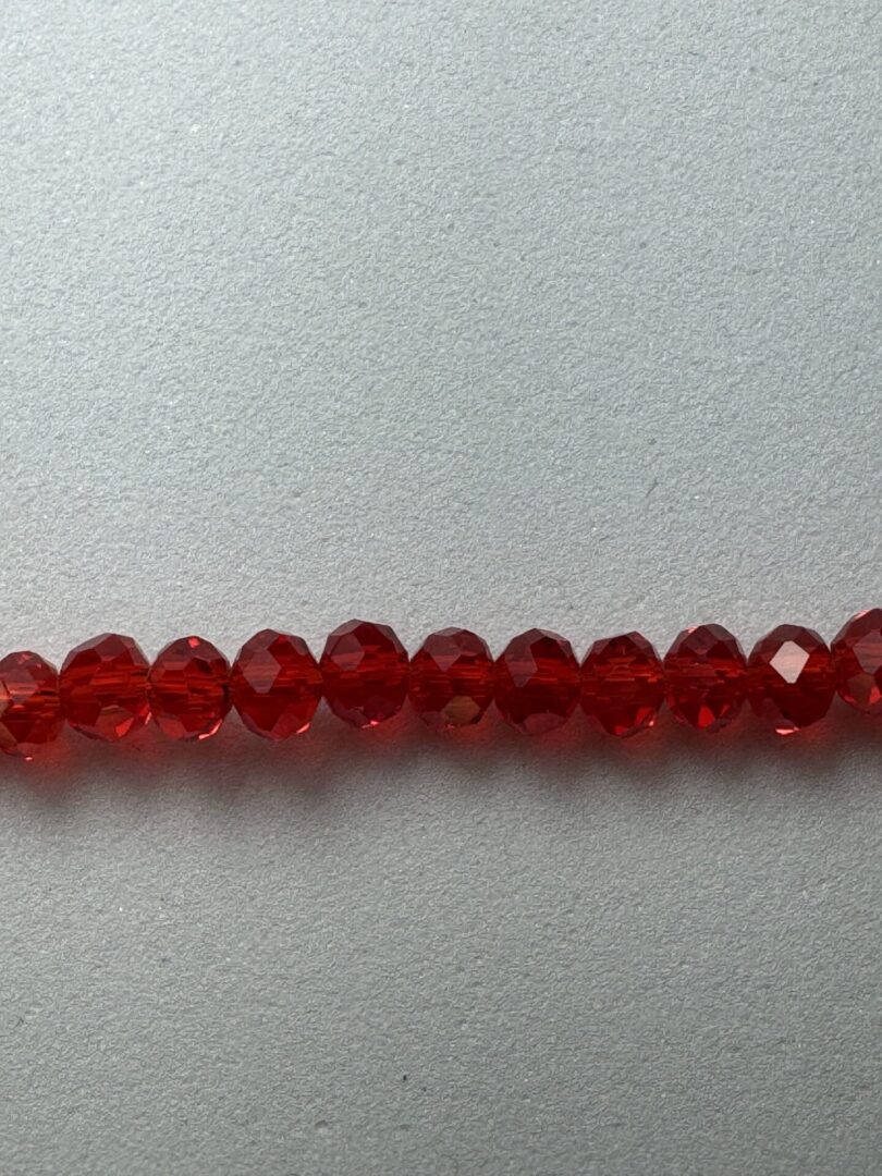 Row of red faceted glass beads.