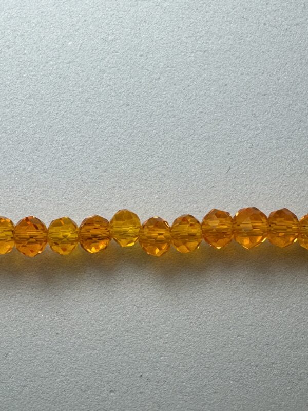 Row of orange faceted glass beads.