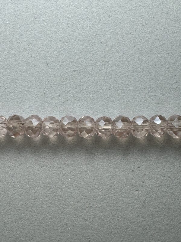 Row of light pink faceted glass beads.