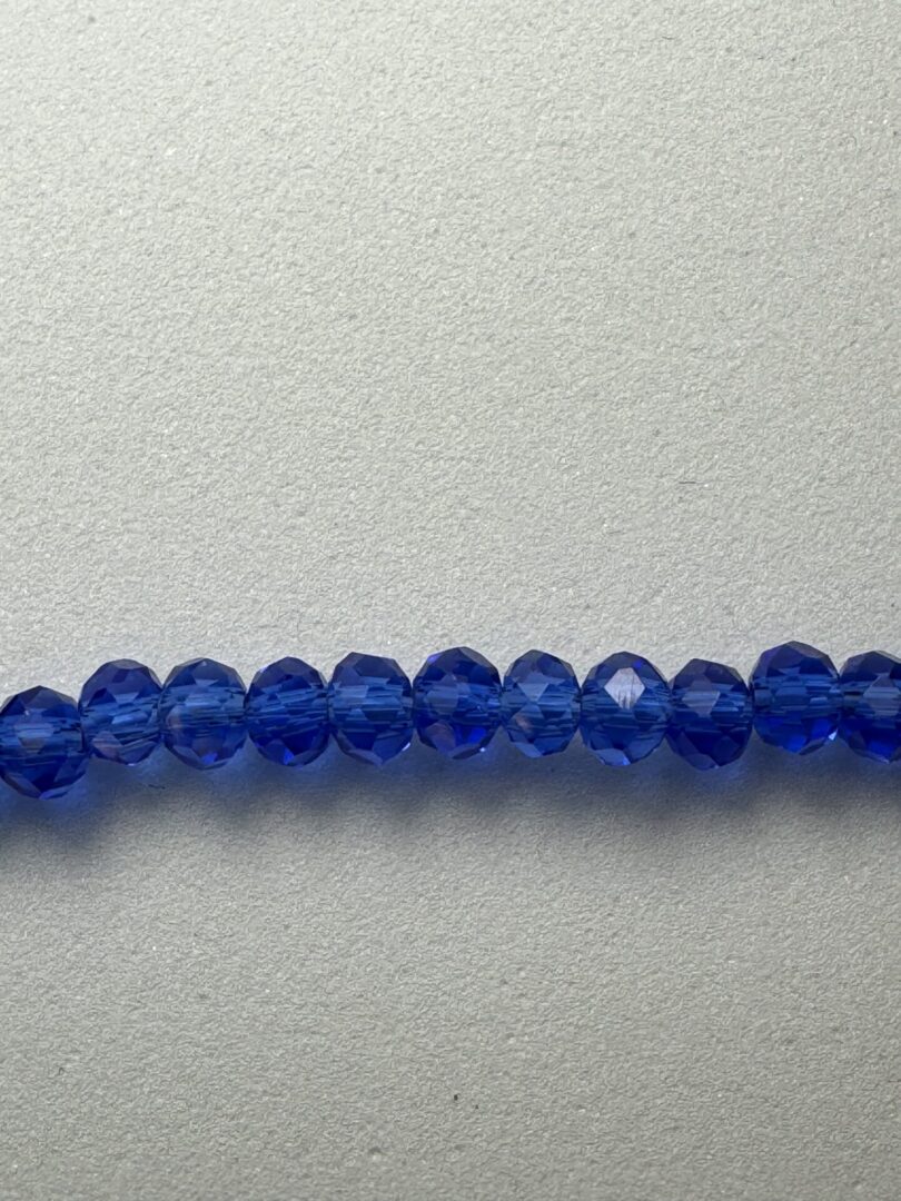 Row of blue faceted glass beads.