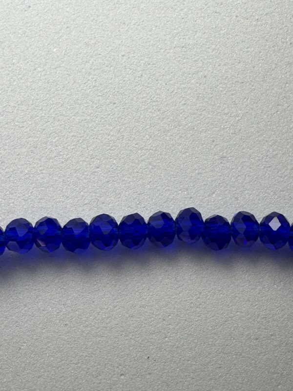 Row of blue glass beads on white background.