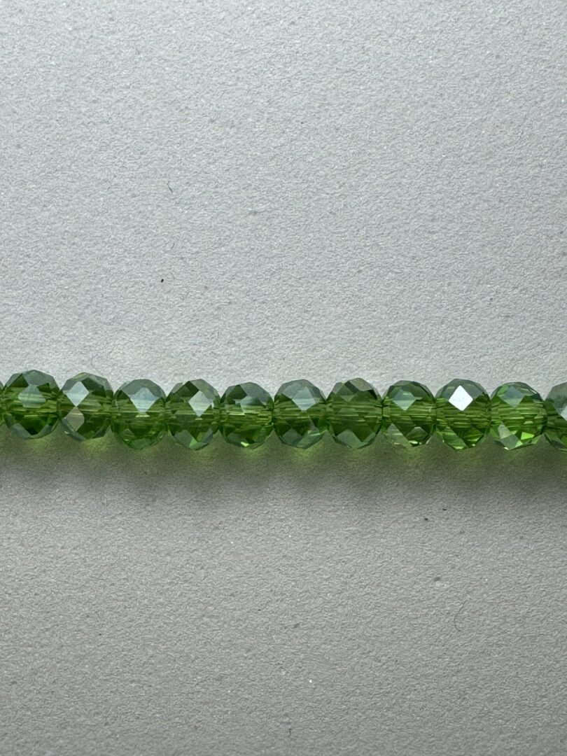 Row of green faceted glass beads.