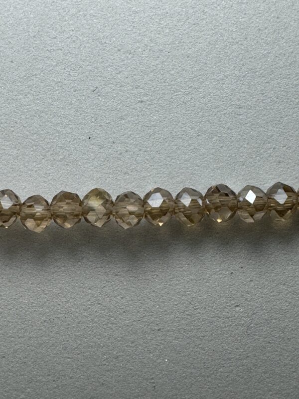 Brown faceted crystal beads on gray background.