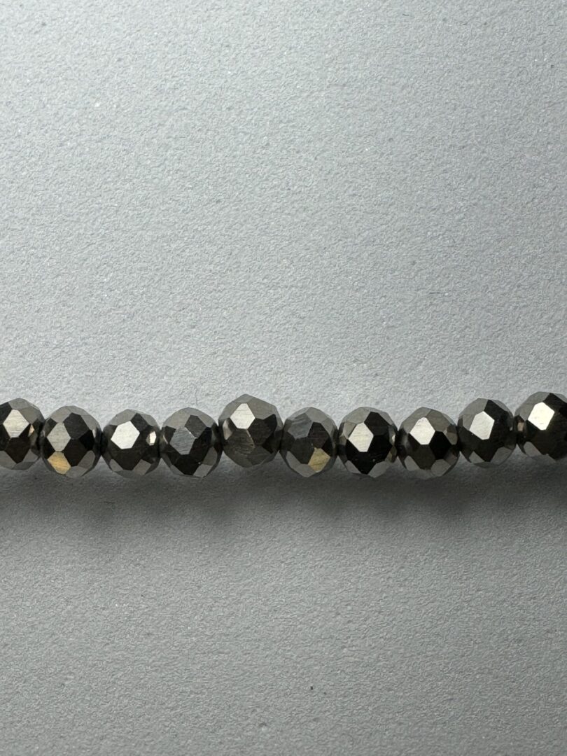 Row of shiny black faceted beads.