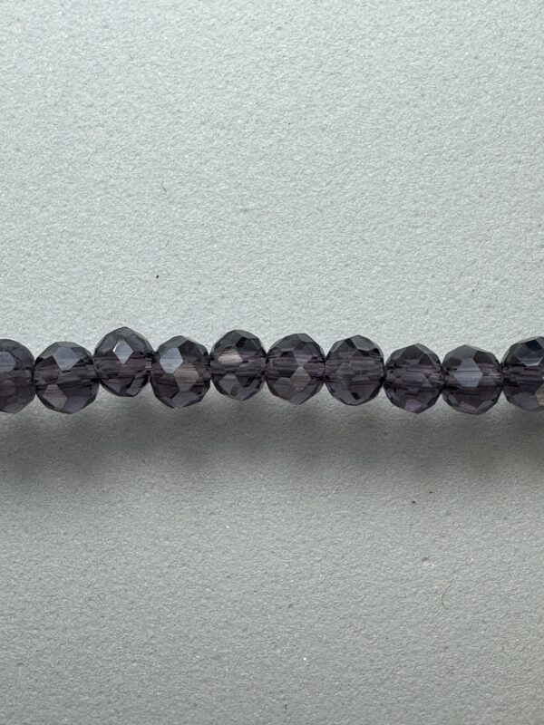 Row of dark purple glass beads.