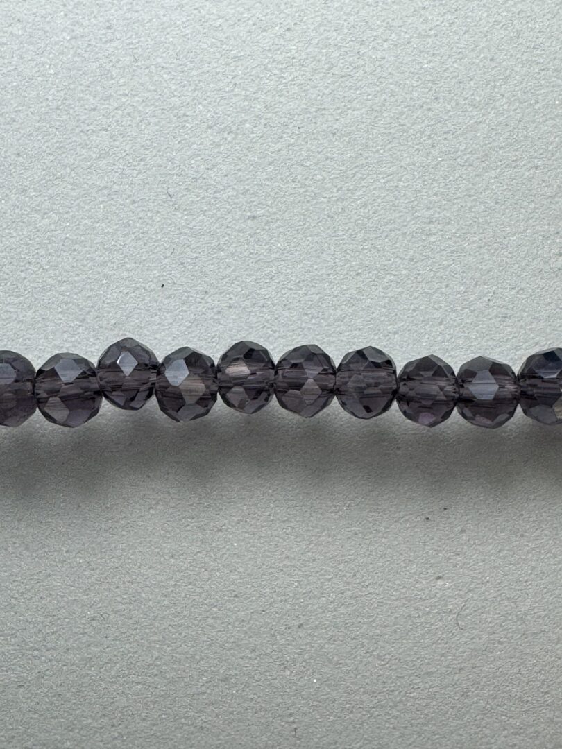 Row of dark purple glass beads.