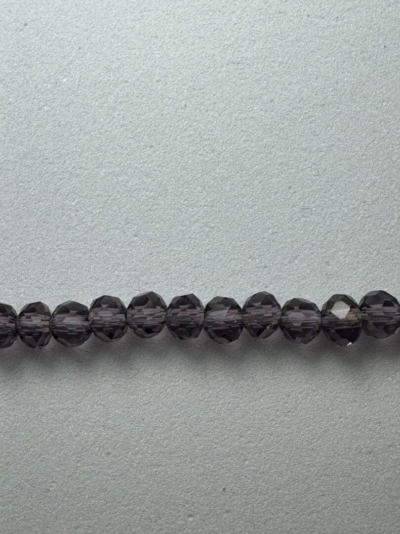 Row of dark purple glass beads.