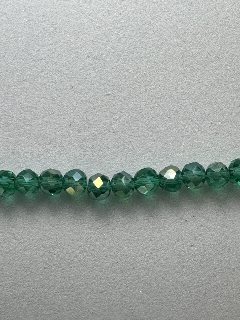 Row of green faceted glass beads.