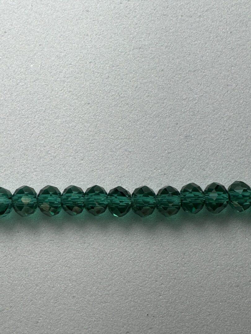 Row of dark green faceted beads.