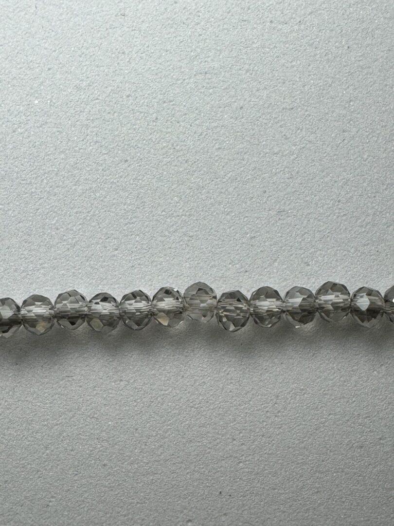 Row of gray faceted glass beads.