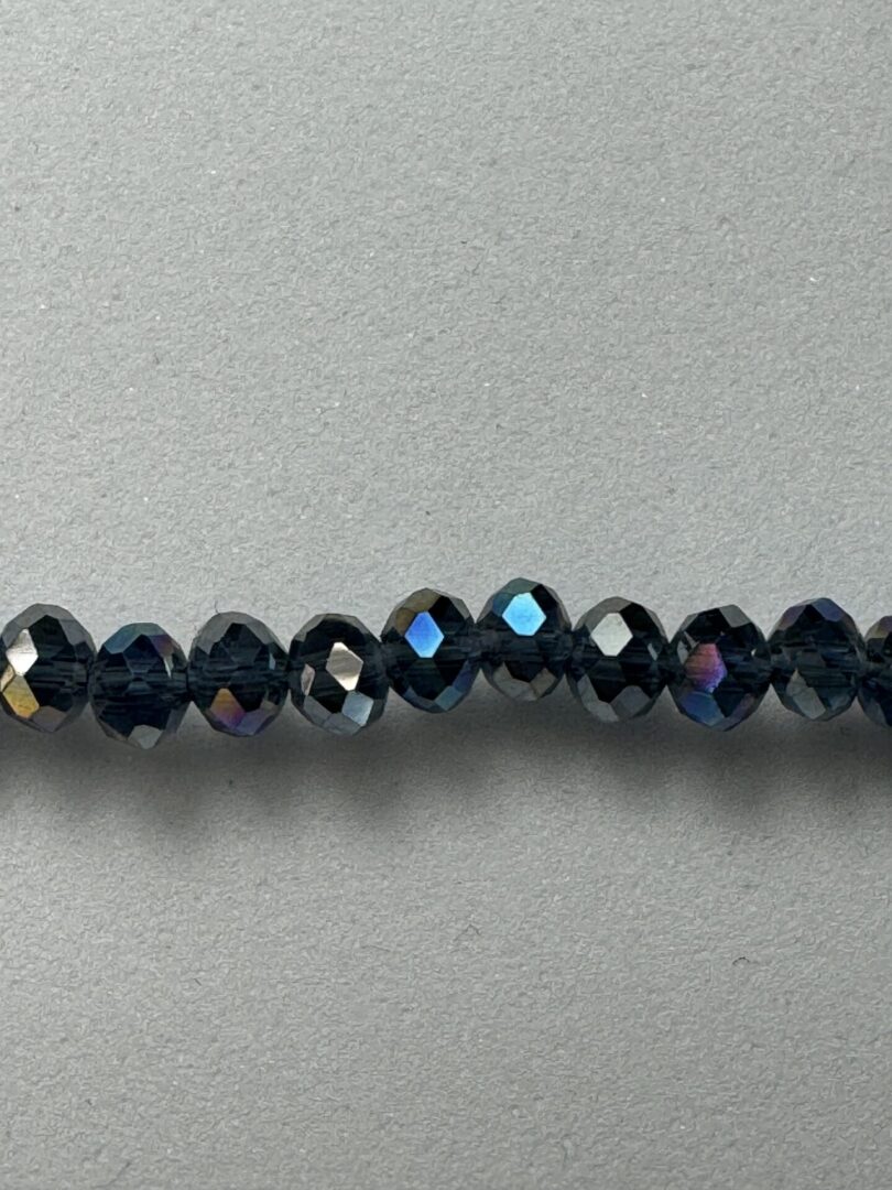 Black iridescent glass beads on gray background.