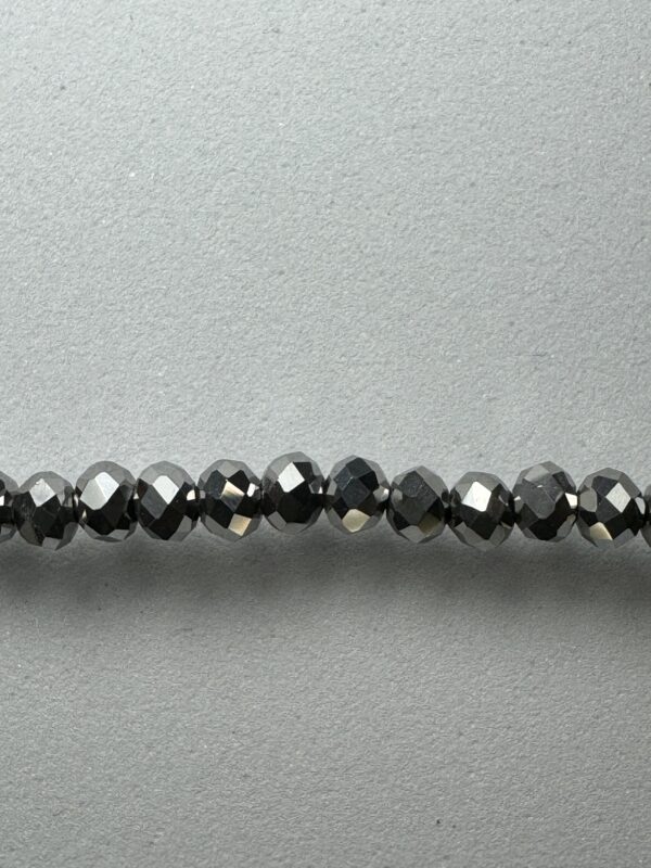 Row of black faceted glass beads.