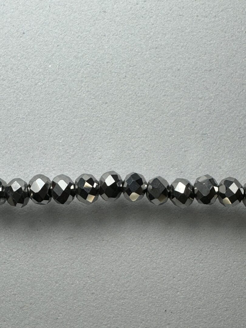 Row of black faceted glass beads.