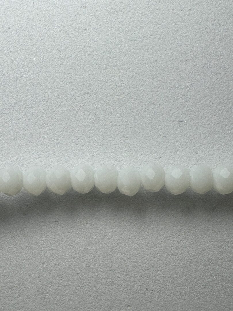 White faceted beads on a gray background.