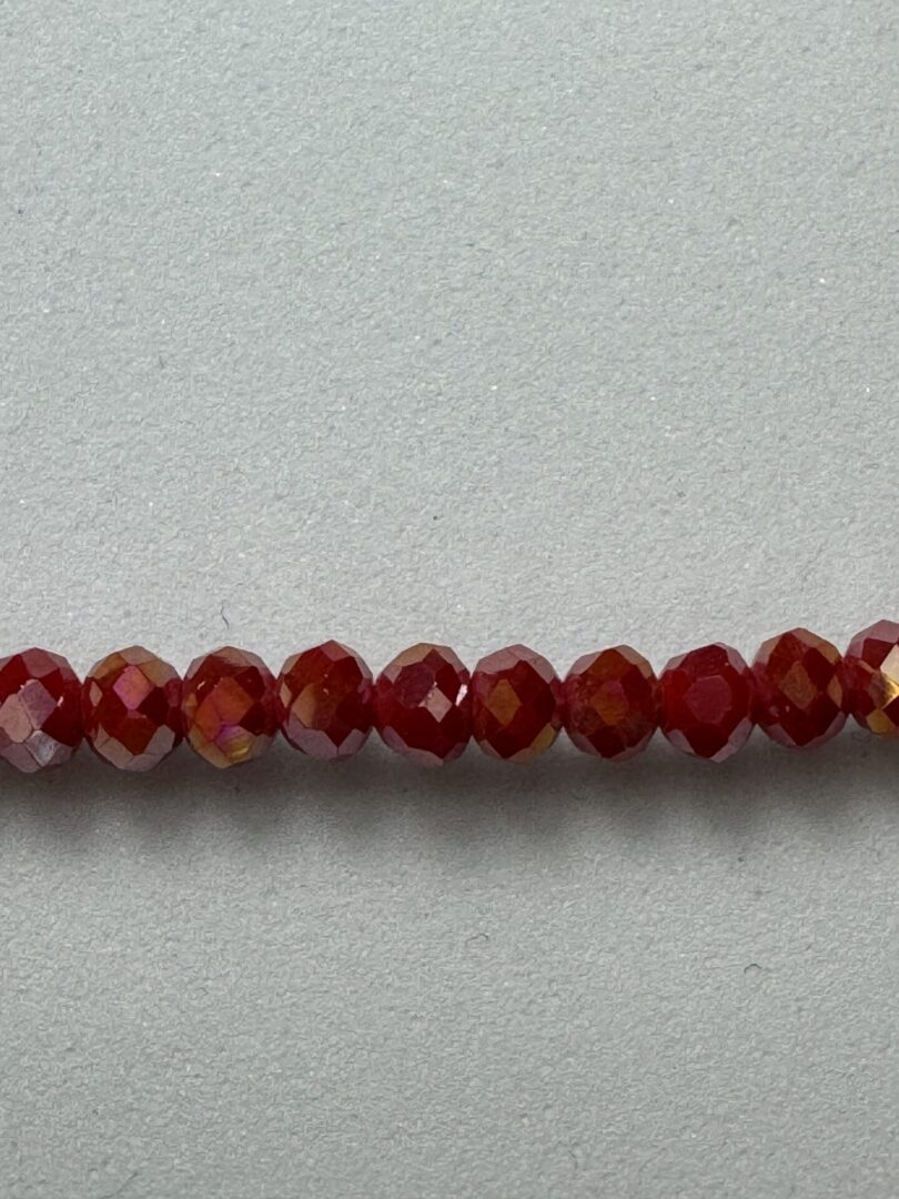 Row of red faceted glass beads.