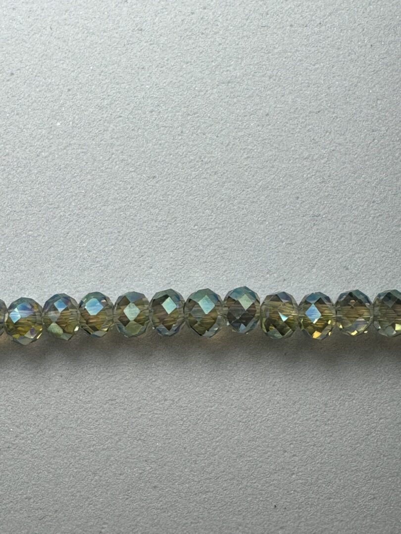 Row of iridescent green glass beads.