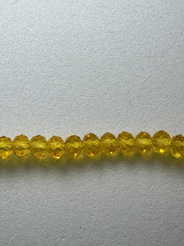 Row of yellow faceted glass beads.