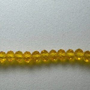 Row of yellow faceted glass beads.