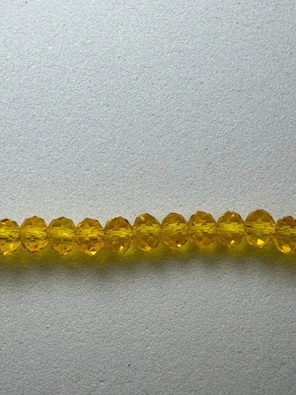 Row of yellow faceted glass beads.