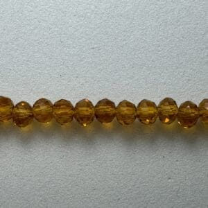 Row of amber glass beads on white.