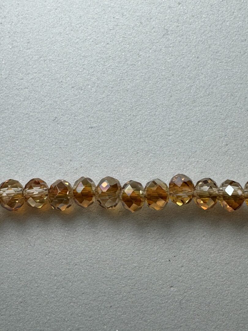 Row of amber faceted glass beads.