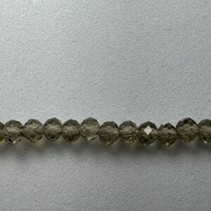 Row of smoky quartz beads on grey surface.