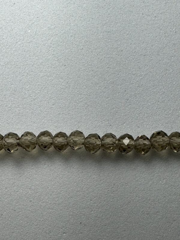 Row of smoky quartz beads on grey surface.