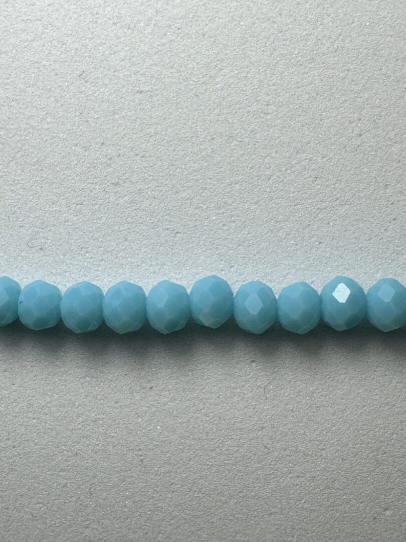 Row of blue faceted glass beads.