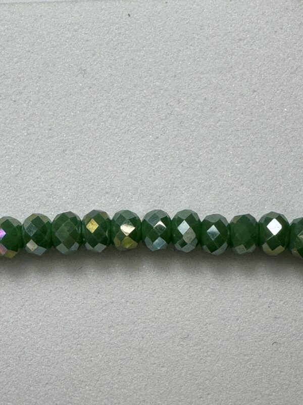 Green faceted beads on a gray background.