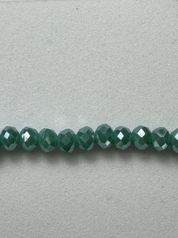 Row of shiny green faceted beads.